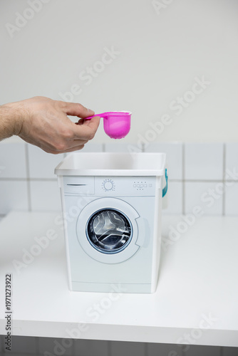 man putting a washing machine to washing machine