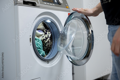 man putting a washing machine to washing machine