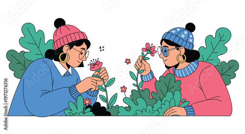Two fashionable women wearing beanies and glasses admire and touch beautiful blooming flowers in a lush green garden setting.