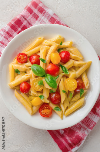 Fresh Penne Pasta with Cherry Tomatoes and Basil on a White Plate