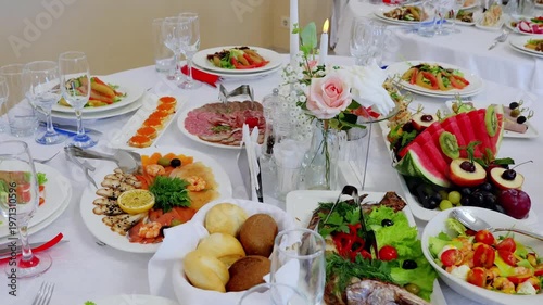 Festive table laden with colorful dishes, grilled fish, roasted meat, fresh salads, ripe fruits, crusty bread
