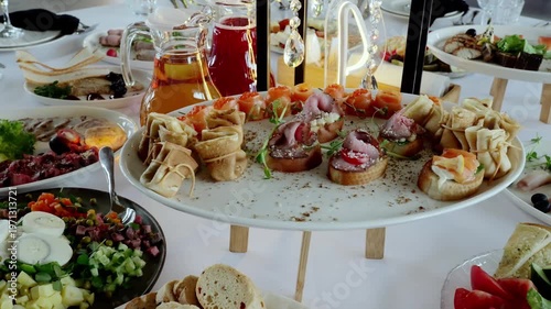 Beautifully decorated catering banquet table presenting various delicious appetizers, salads, and drinks, creating an inviting atmosphere for guests