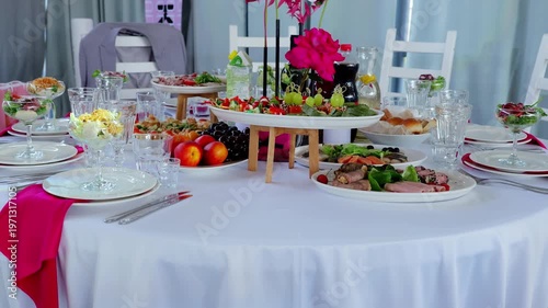 Refined dining table covered in white linen, presenting multi level centerpiece with colorful cuisine, magenta napkin accents, soft rainbow illumination highlighting elegant setting