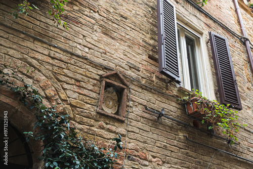 Pienza Tuscany Italy narrow street with stone buildings and plants