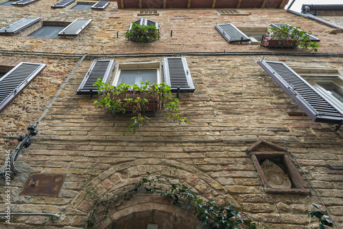 Pienza Tuscany Italy narrow street with stone buildings and plants