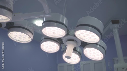 Low-angle view of a bright multi-LED surgical lamp in an operating room, providing high-intensity illumination for medical procedures.