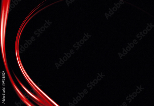 Abstract red light trails curving on dark background, futuristic motion and energy