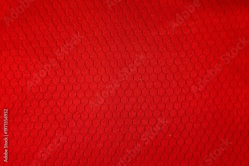 Bright red athletic jersey fabric with honeycomb mesh ventilation pattern