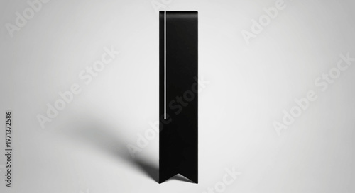 Minimalist black design of a sleek object with a white highlight against a soft background