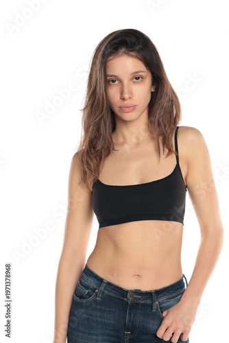 Studio shot of a young woman with natural skin and no makeup wearing a black top, calm neutral expression, portrait on white background