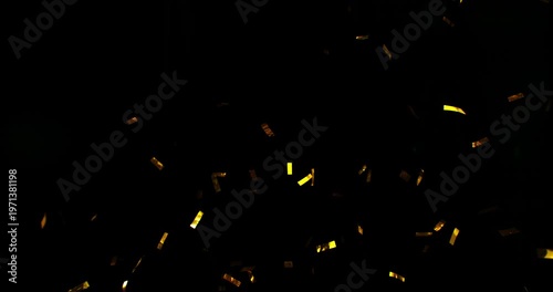 Golden confetti flying in super slow motion against a black background. Shiny metallic particles drifting and falling in the air, creating elegant festive atmosphere with dramatic lighting. Speed ramp