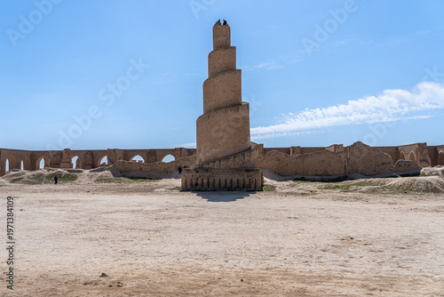 A striking minaret, built with layered brickwork, commands attention against the vibrant blue sky in Abu Dulaf, Iraq