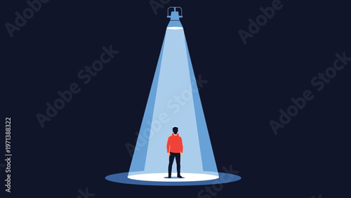 Man standing alone under bright spotlight beam in dark room representing fame success or loneliness.