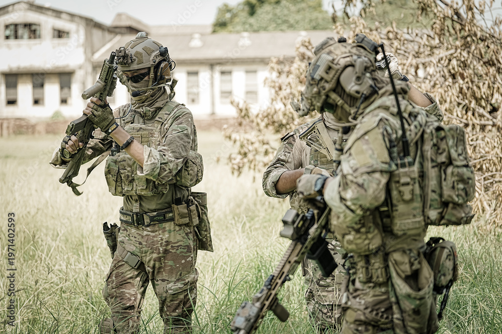 Fototapeta premium Special forces soldiers in camouflage gear with rifles stand in a grassy field