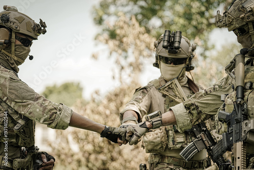 Special forces soldiers in camouflage gear fist bumping in solidarity outdoors