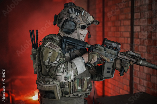 Photos Soldier in tactical gear with rifle, ready for action in a dimly lit environment