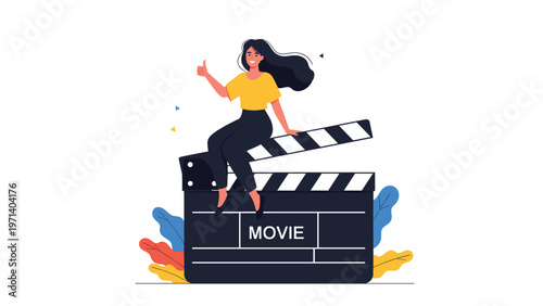 Happy woman sitting on a large movie clapperboard giving a thumbs up sign representing successful film production work.