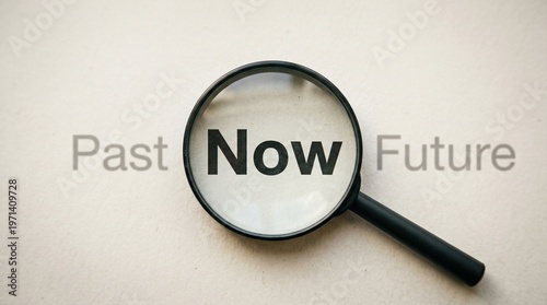 Focus on the Present: A magnifying glass highlights the word Now, emphasizing the importance of the present moment while blurring the concepts of the Past and Future.