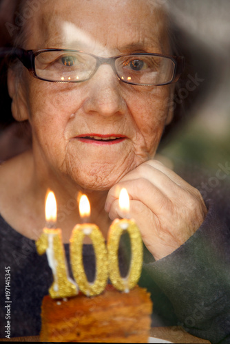 Konstfotografi Portrait of an elderly woman with glasses holding anniversary candles