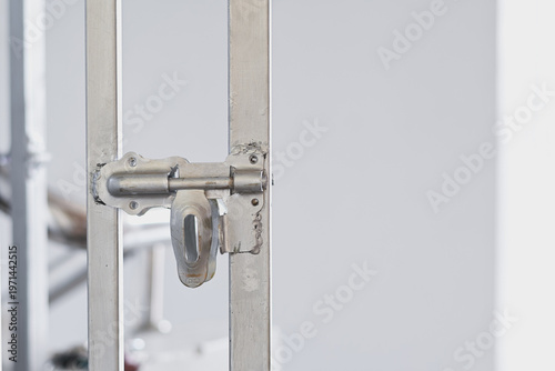 A metal door bolt latch on a gate.