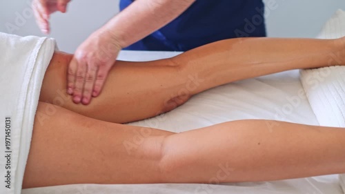 A professional therapist performs a soothing calf massage using oil to promote relaxation and enhance wellness.