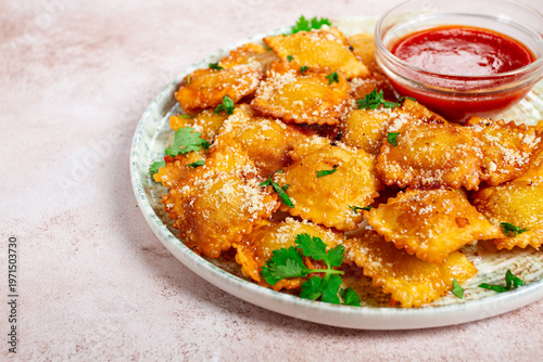 fried ravioli with parmesan cheese, served with red sauce and garnished with herbs, on a light background, no people,