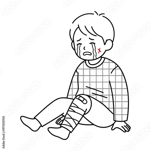 A young boy sitting on the ground crying with a bandage on his injured knee and cheek