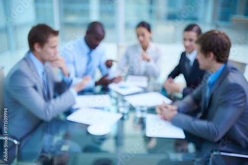 Diverse business people in suits gathered around a glass table for a meeting business meeting