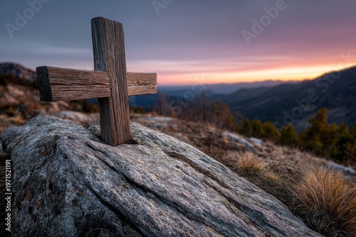 Sunset cross standing on rocky peak in the mountains