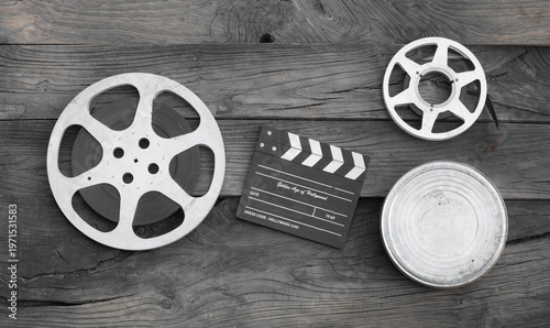 Photos movie clapperboard and film strip on a wooden background