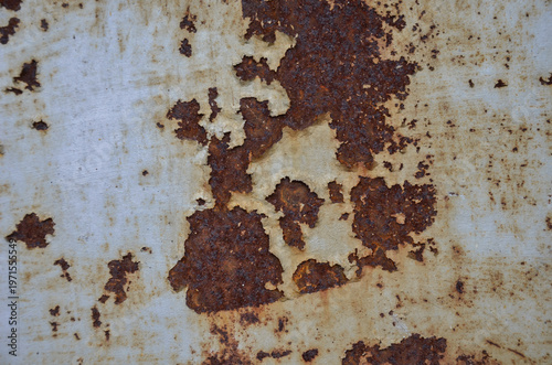 old rusty metal background. Textured industrial background featuring metal corrosion through layers of old paint. Grungy weathered steel surface with a distressed look.