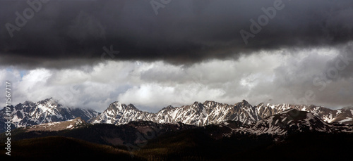 Beautiful Vail Colorado mountain top view of the Rocky Moutains visible at the top of Vail Ski Resort.  Heavy storm clouds help frame the snowy mountains.