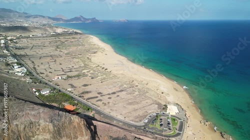 Aerial view of drone flying over golden sand beach with a small rock island in Porto Santo, Madeira, Portugal. Portuguese paradise with clean transparent water.
