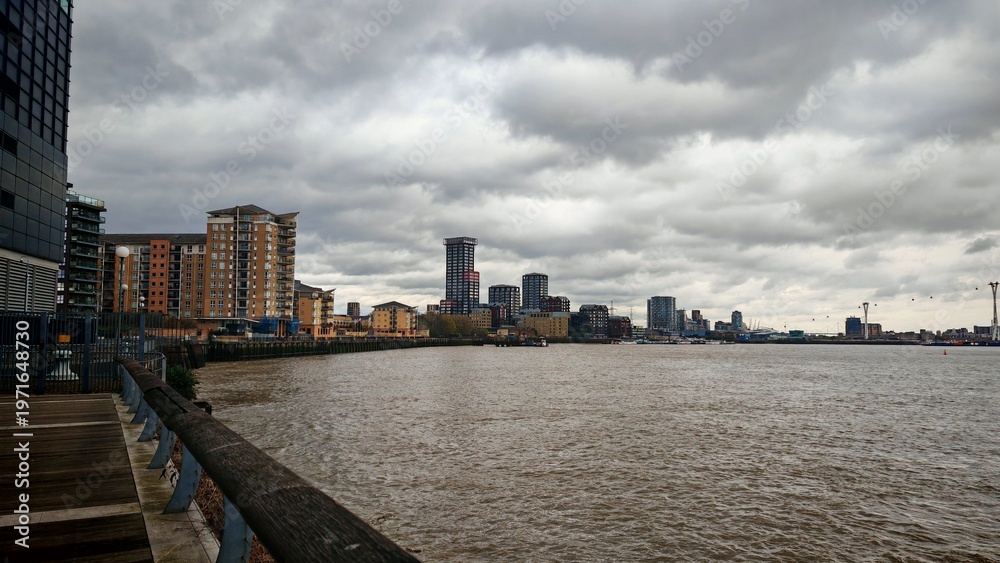 Fototapeta premium Modern Residential Buildings Along the River Thames under a Cloudy Sky, London