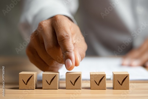 Hand of african adult male pointing at checked wooden blocks on desk