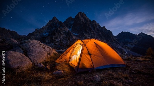 Illuminated Orange Camping Tent in Rocky Terrain