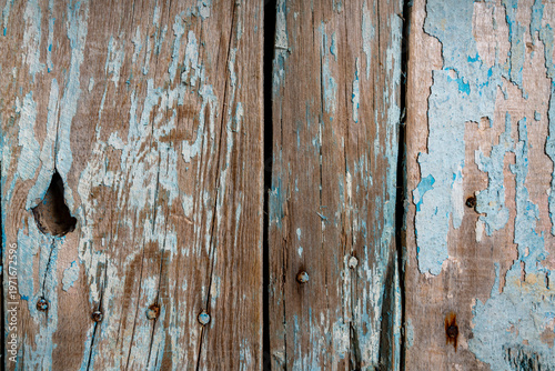 Close-up of weathered blue painted wooden planks with peeling layers, cracks and aged texture. Rustic surface ideal for vintage backgrounds and design use.