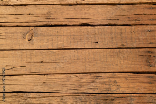 Close-up of natural weathered wooden planks showing detailed grain, cracks and aged texture. Rustic organic surface perfect for backgrounds and design.