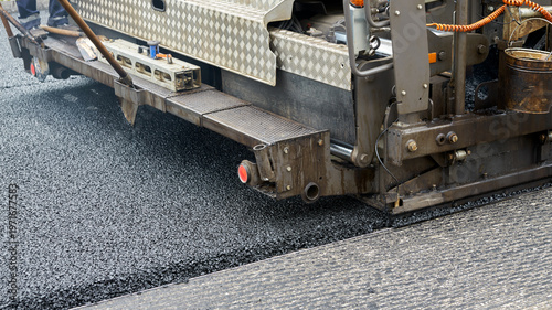 Fotografía The lower part of the asphalt paver against the background of a flat road surface