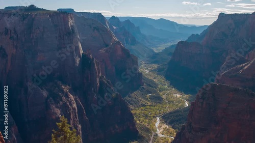 An expansive, high-angle view of the dramatic Zion Canyon from the Observation Point overlook, accessed via the East Mesa Trail in Zion National Park, Utah. The footage captures the early morning ligh