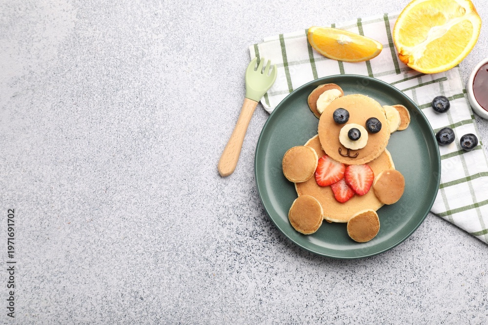 Fototapeta premium Creative serving for kids. Cute bear made of pancakes, fruits and jam on grey table, flat lay. Space for text