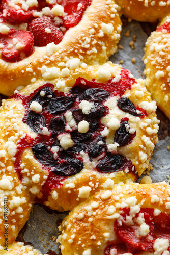 Sweet yeast buns with the addition of strawberries, haskap berries and butter crumble, close-up