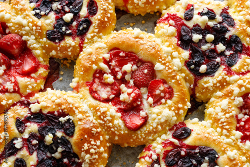 Sweet yeast buns with the addition of strawberries, haskap berries and butter crumble, close up