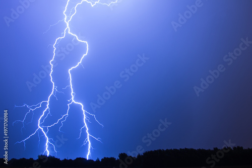 A vivid flash of lightning against a blue sky