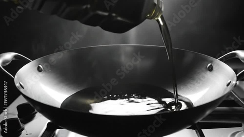 Pouring cooking oil into a stainless steel wok on a gas stove in preparation for cooking