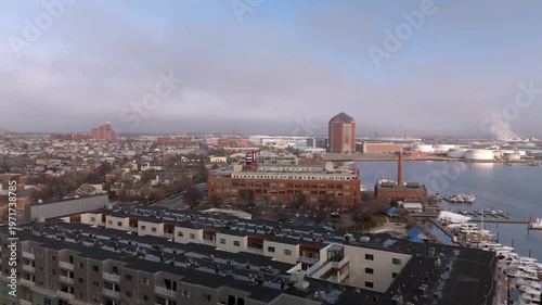 The Canton Waterfront in downtown Baltimore with boats in view, apartments near by along with the Korean War Memorial