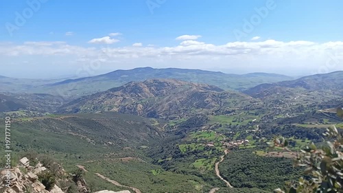 A serene video showcasing a breathtaking mountain landscape with lush greenery under a clear blue sky.