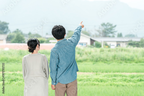Принти на полотні A young couple (looking to relocate, searching for land) gazing at the rural scenery