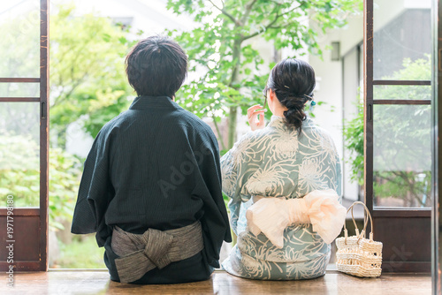 Foto A couple in yukata (traditional Japanese summer kimono) relaxing on the veranda of a traditional Japanese house