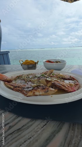 Fish in dish on the beach, tasty meal.  Vertical video.